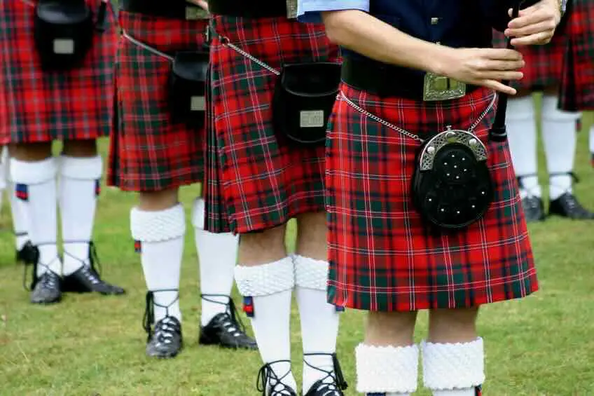 Pipe band members wearing red tartan kilts