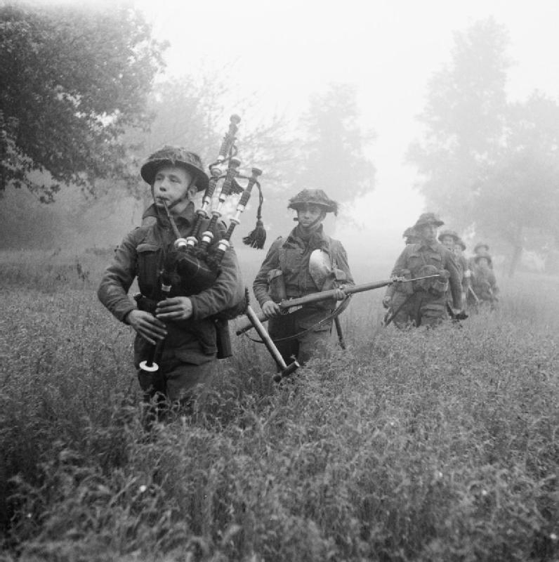 Led by their piper, men of the 7th Seaforth Highlanders, 15th (Scottish) Infantry Division advance during Operation Epsom, 26 June 1944.