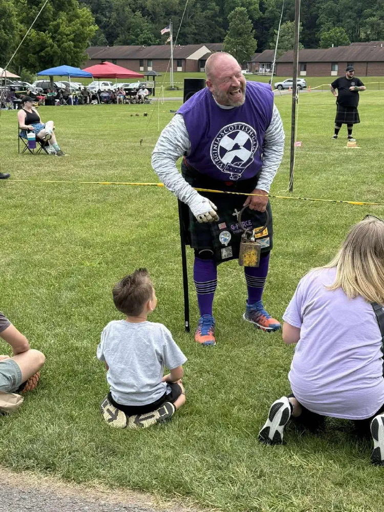 Highland athletics participant demonstrating a weight to spectators