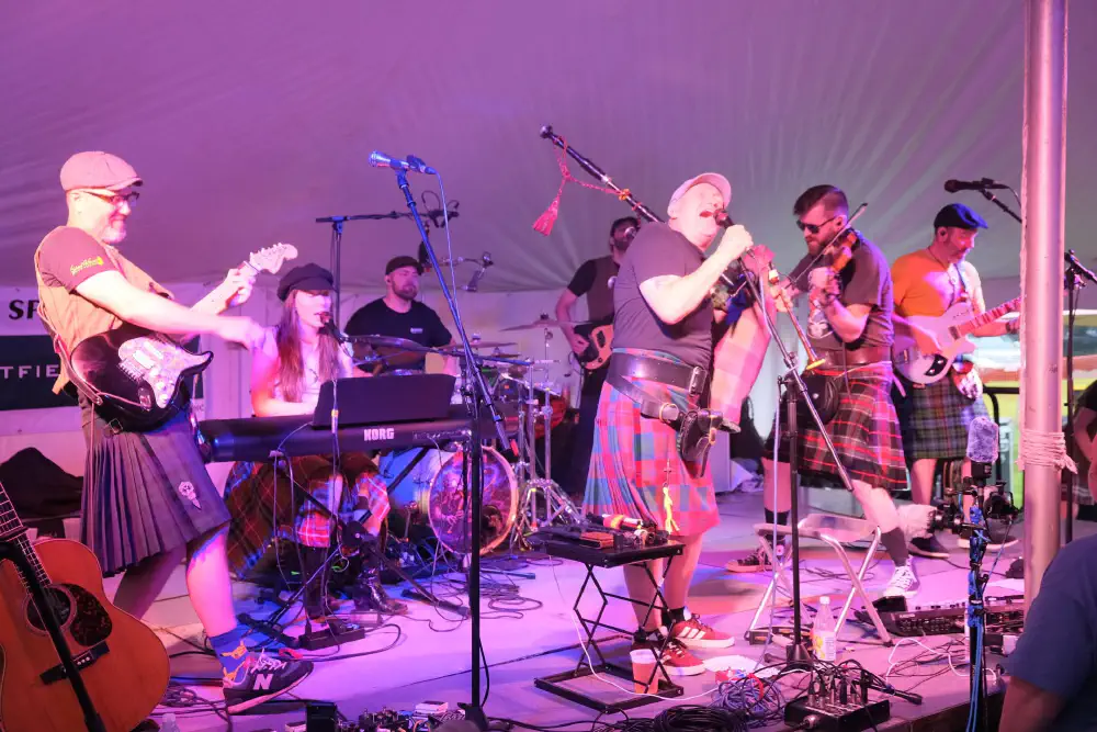 Musicians performing on stage at the Glasgow Lands Scottish Festival
