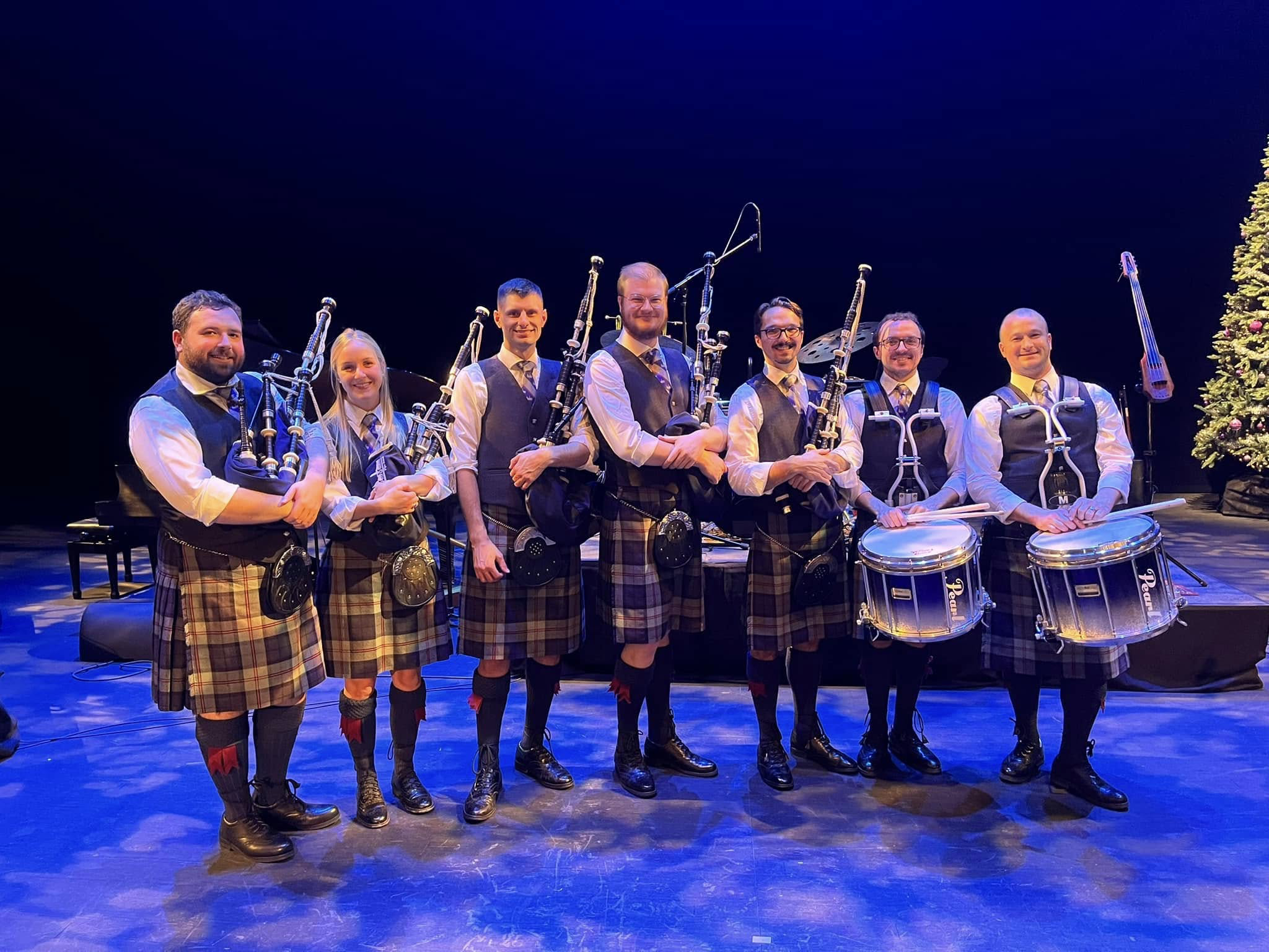 MacMillan pipers and drummers gathered on stage