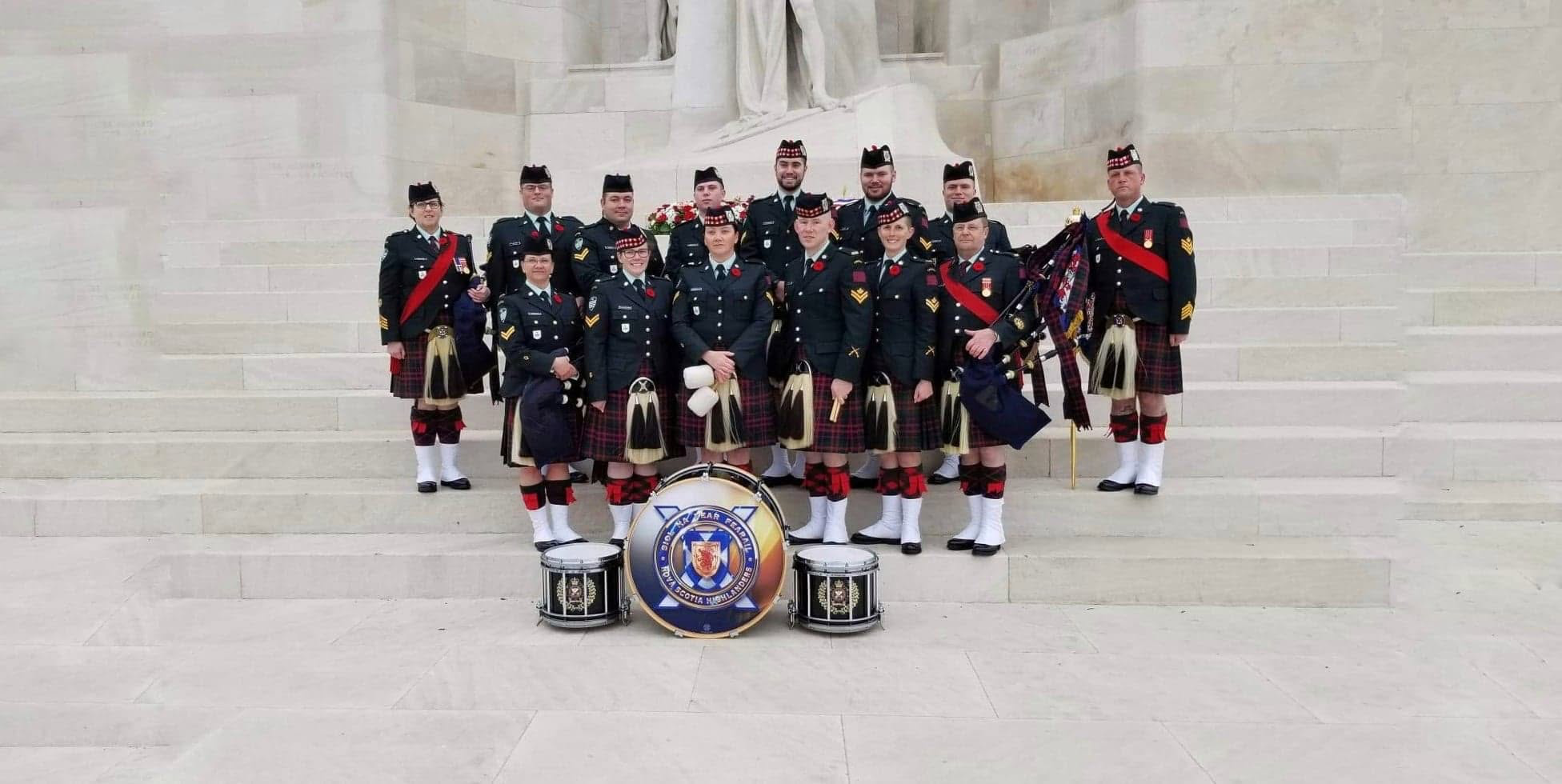The Nova Scotia Highlanders Pipes and Drums gathered with their instruments at a memorial