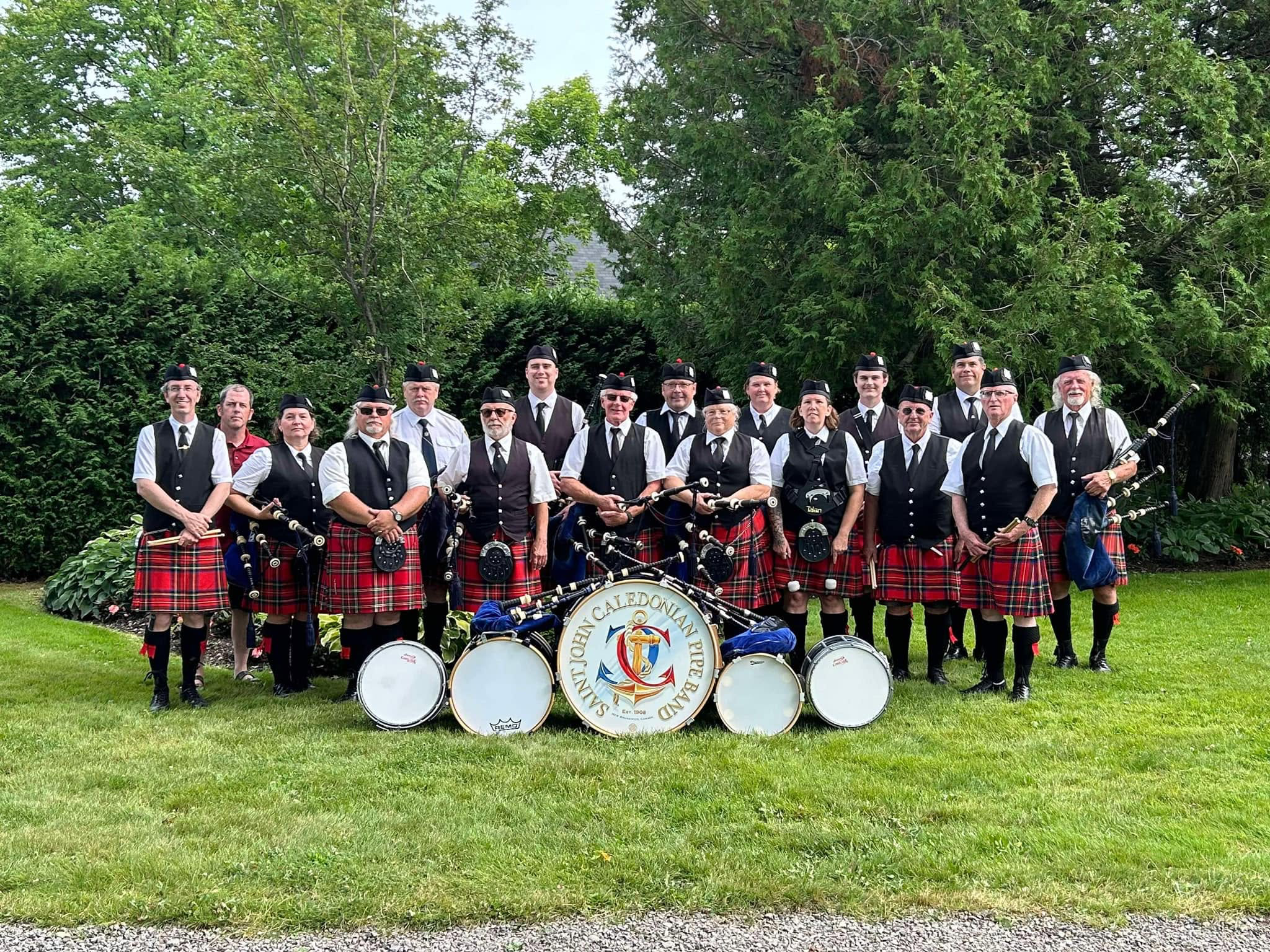 Saint John Caledonian Pipe Band gathered outdoors with pipes and drums