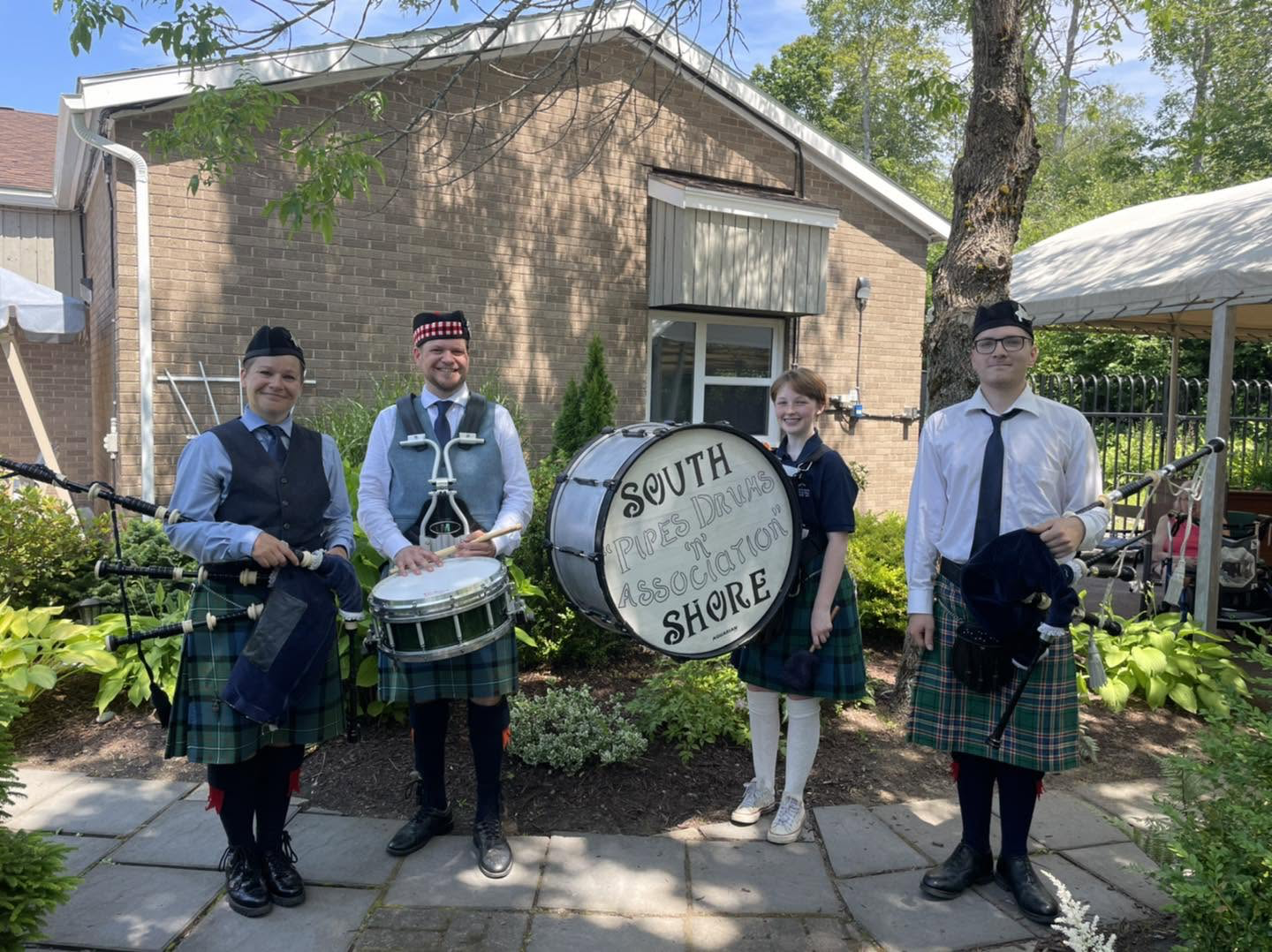 South Shore Pipes and Drums Association members with their instruments outdoors