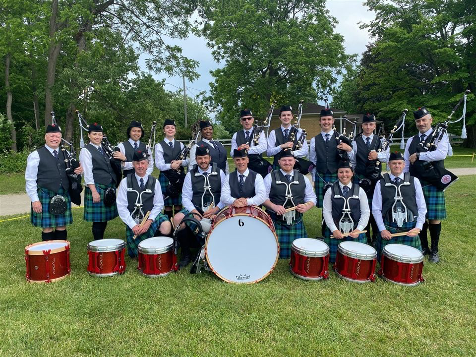 St. Andrew’s College Association Pipe Band gathered with its red drums